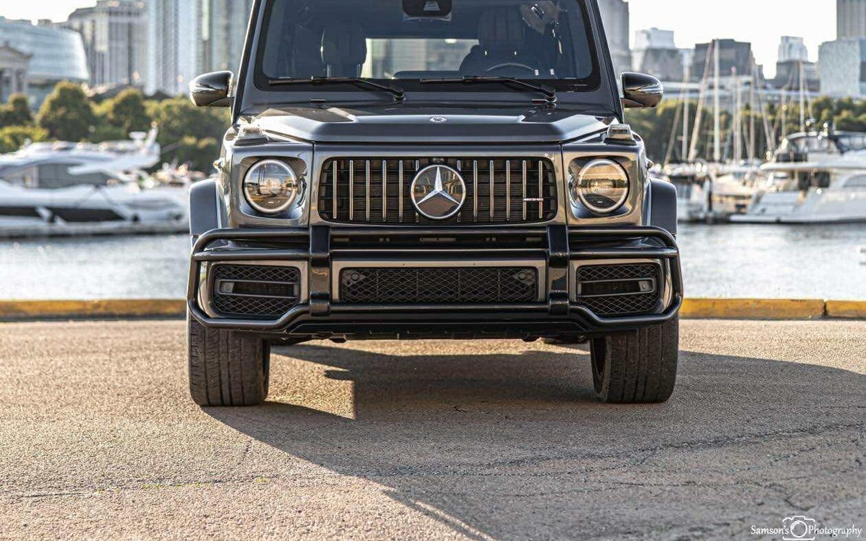 Graphite gray Mercedes-AMG G63 by a Chicago harbor with the skyline behind